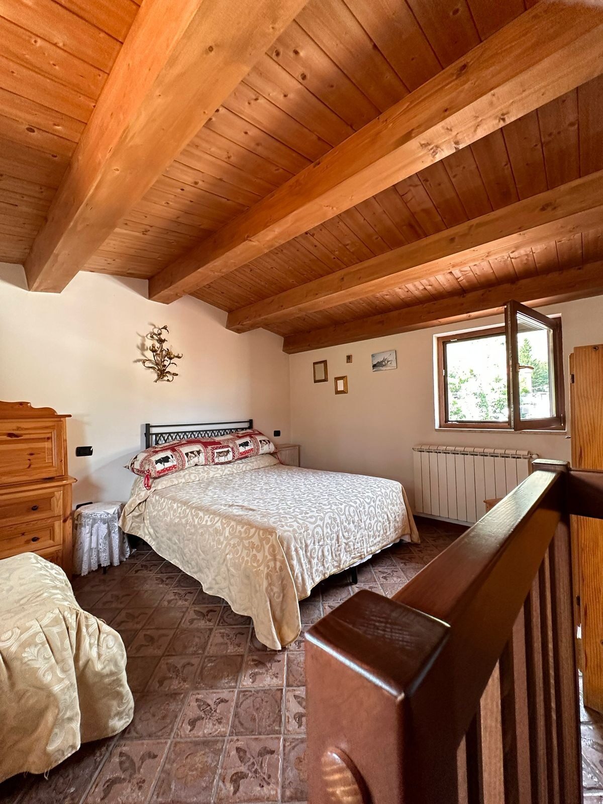 Camera al piano superiore con soffitto in legno