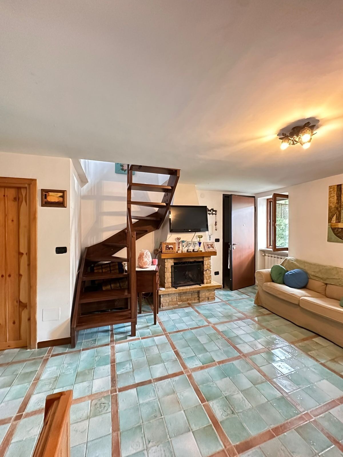Soggiorno di Lovely House con travi in legno e scala